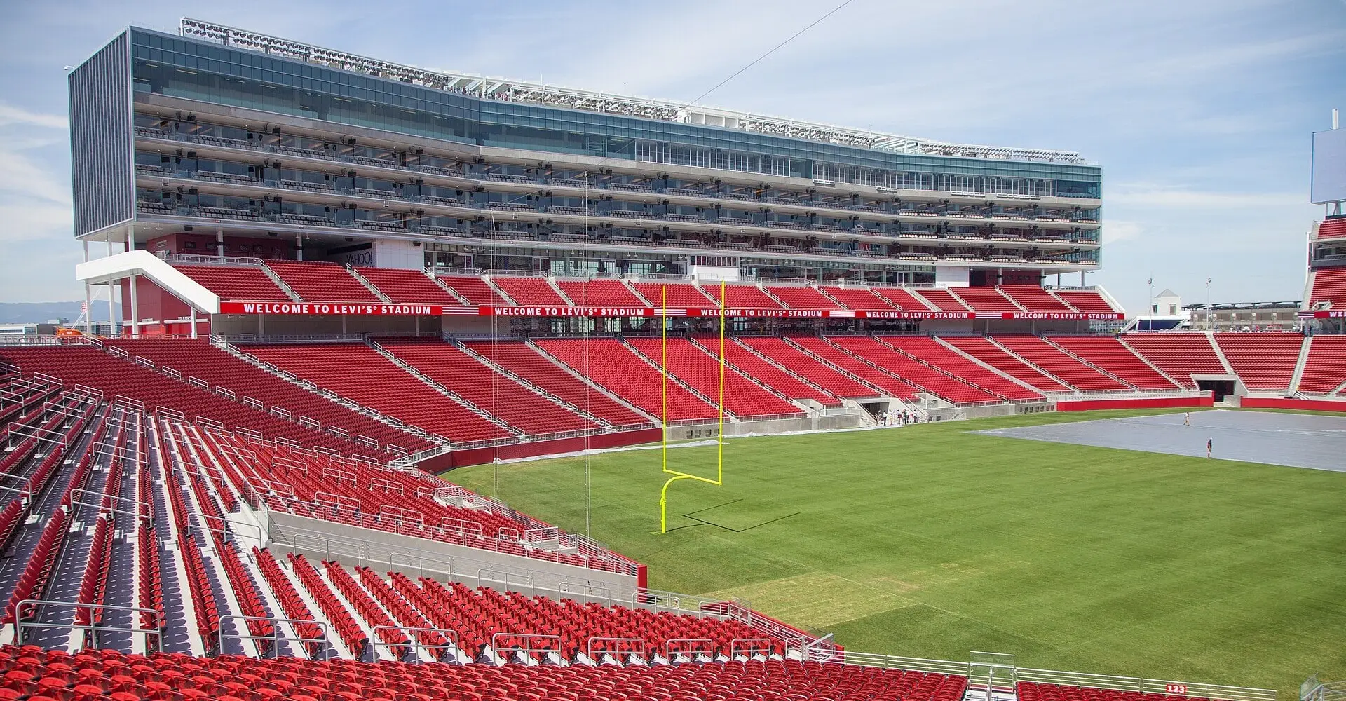 Levi's Stadium seating bowl and grass field in bright sun, looking across the end zone toward the suite tower and scoreboard